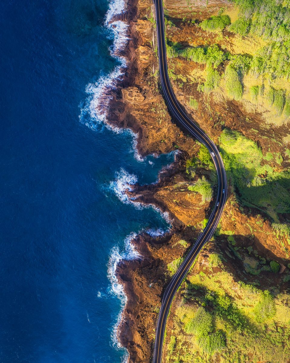 Straight-down aerial of Kalanianaʻole Highway winding along the rugged Kaiwi coast beside deep blue ocean
