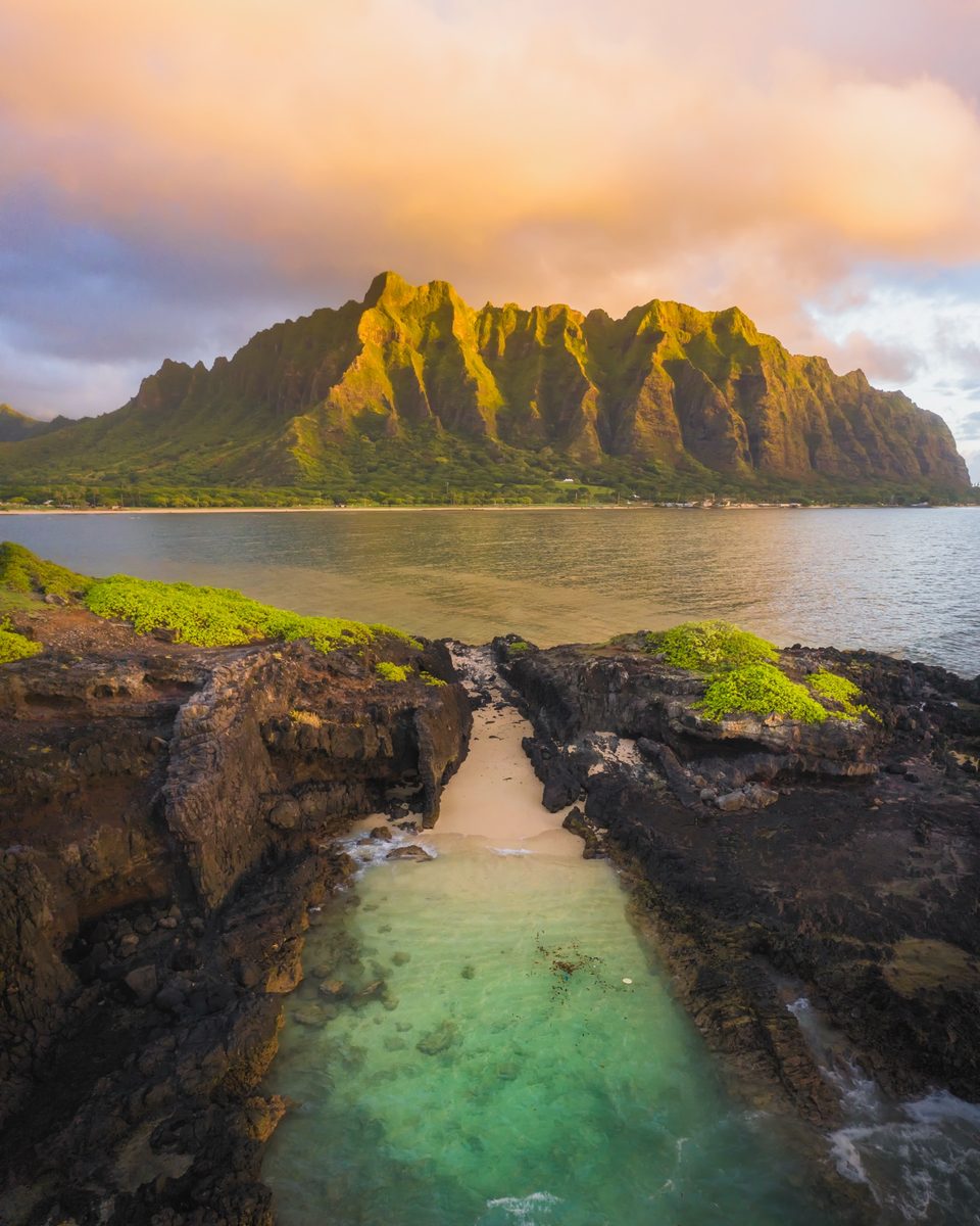 The Kualoa ridge at sunrise seen from the rocks of Mokoliʻi, a narrow channel of clear water in front
